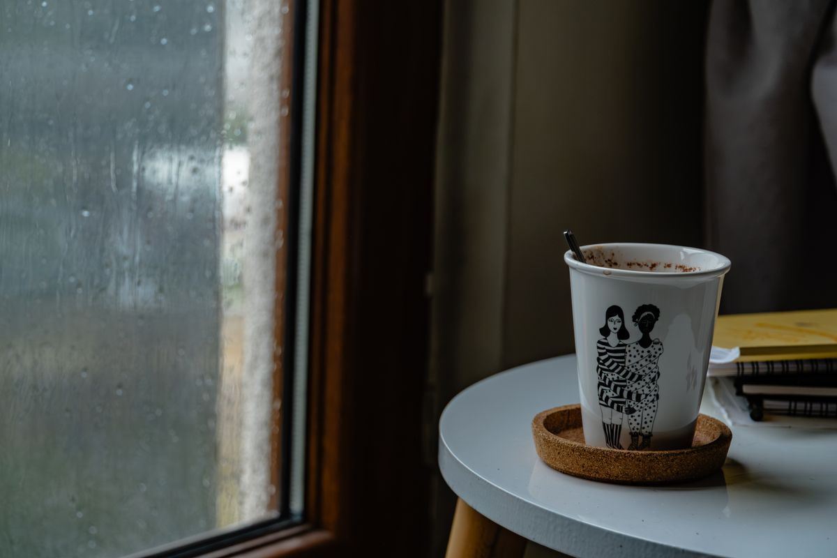 雨の日の窓辺に置かれたコーヒー