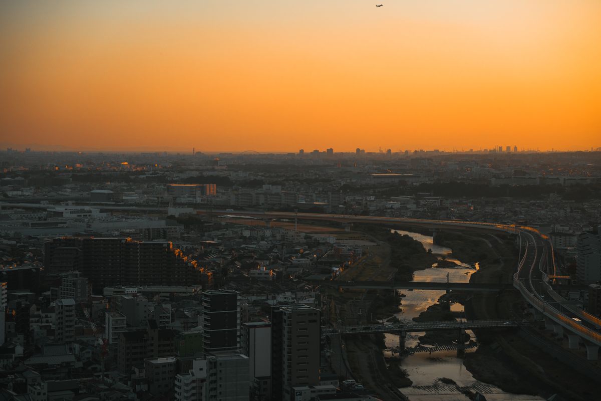 夕焼けに染まる空と川沿いの街並み