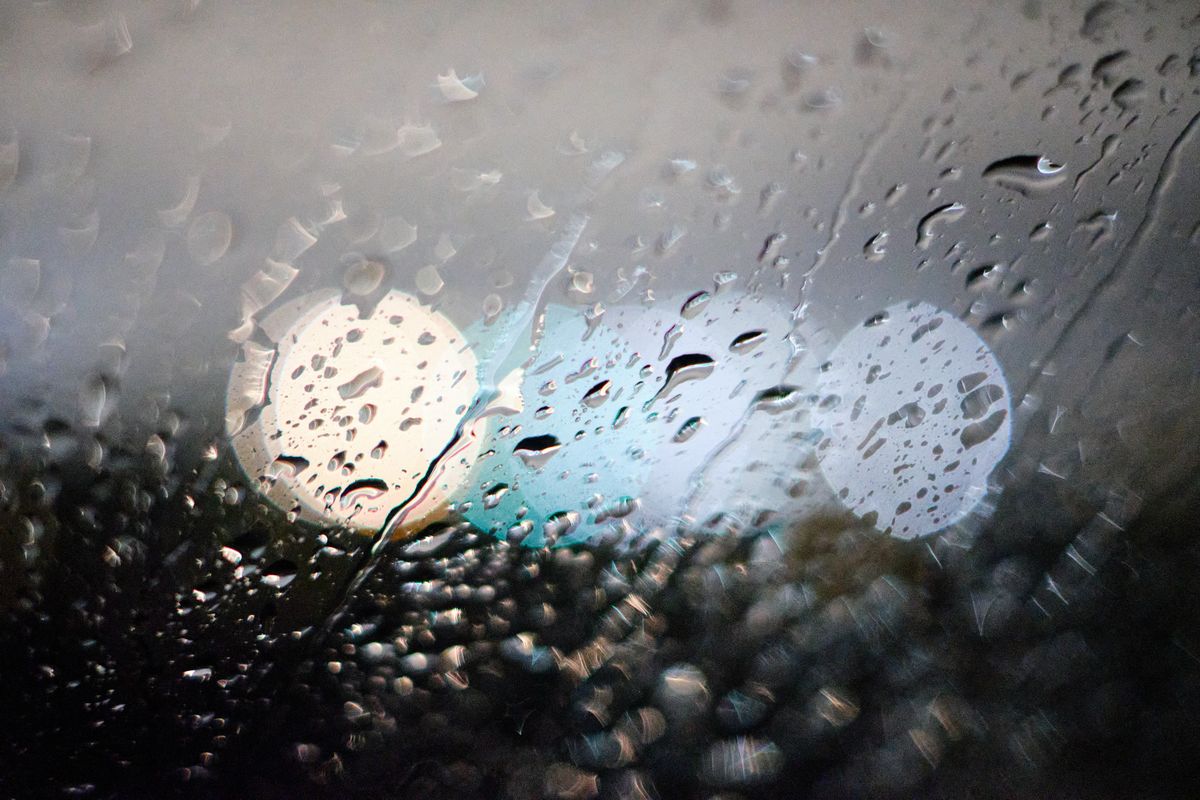 雨粒のついた窓越しに見える丸いにじんだ光