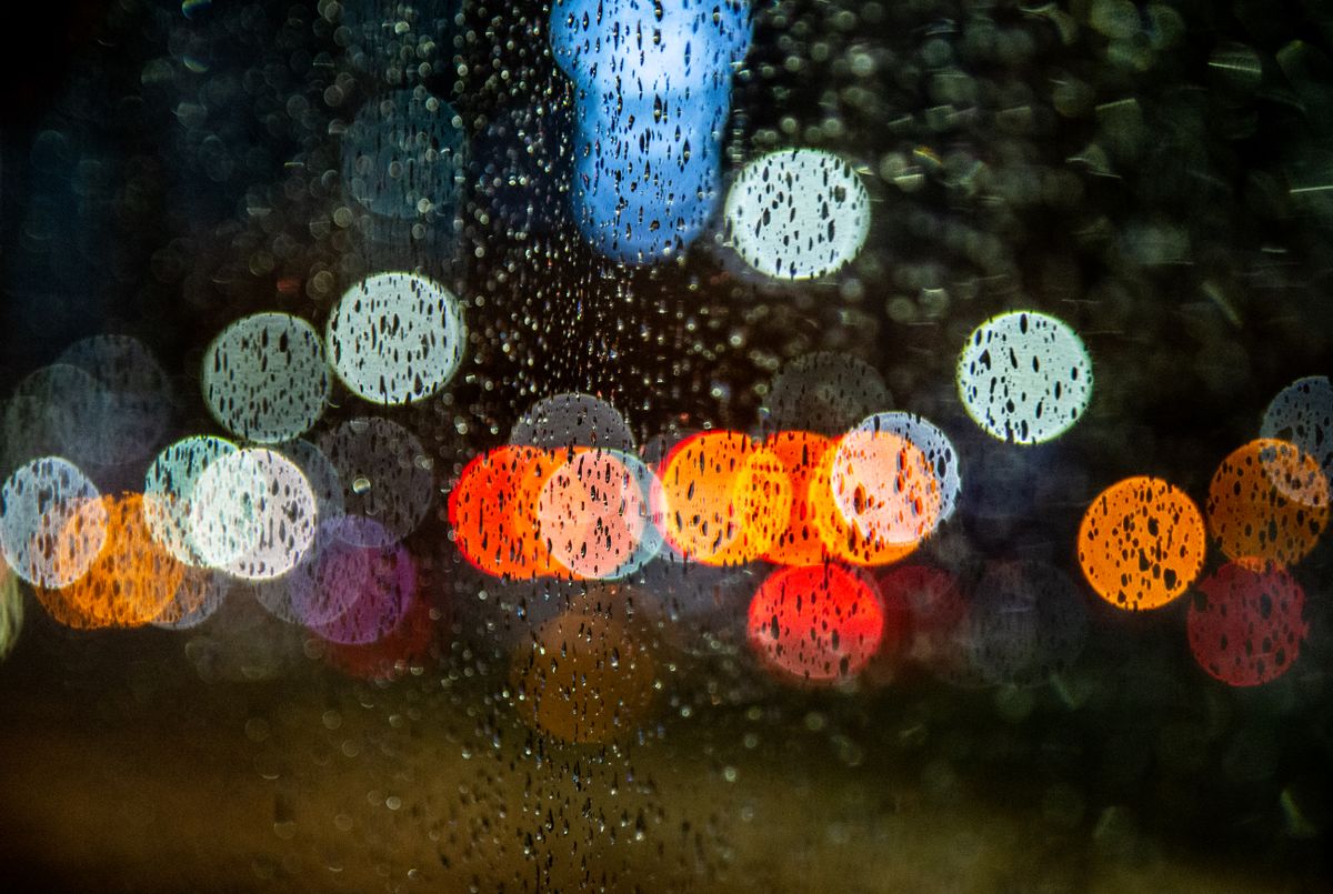 雨粒の付いた窓越しに滲む夜の街の光