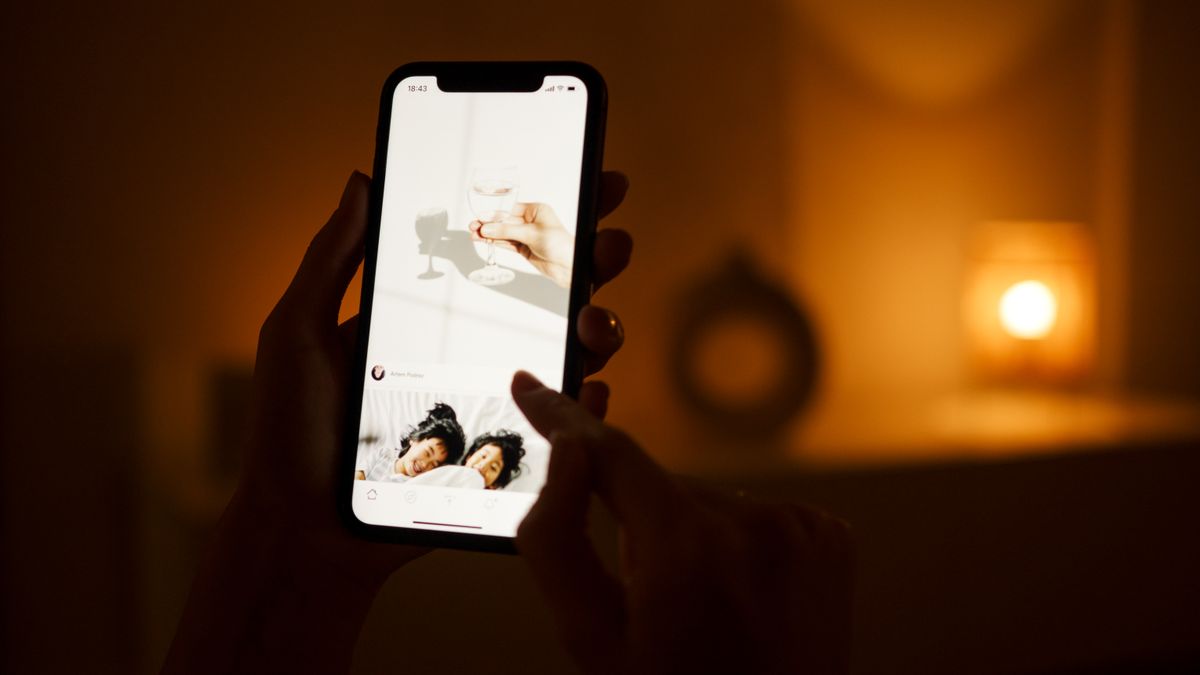 暖かい明かりの部屋でスマホを見る
